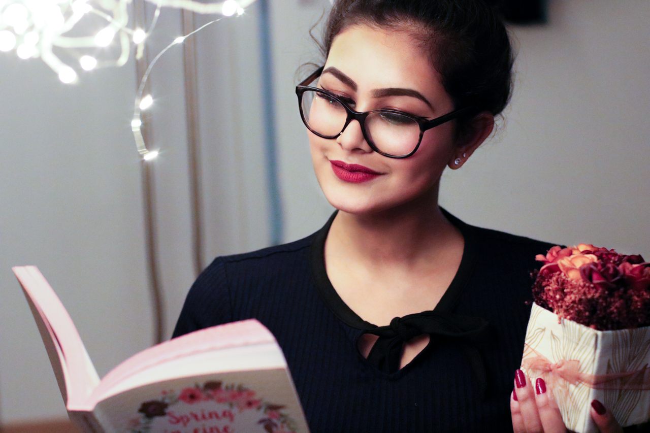 kobieta w okularach czytająca książkę 